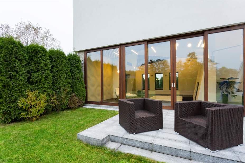 Terrasse moderne avec vue sur un intérieur lumineux à travers une grande baie vitrée.