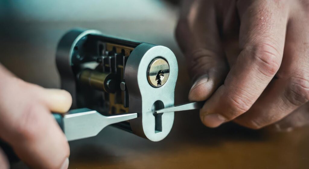 Gros plan sur les mains d'un technicien manipulant des outils de précision sur un cylindre, indispensable pour une ouverture de porte sans degats serrurier paris.